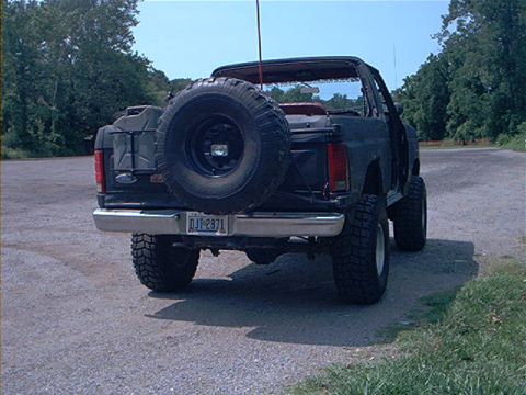 1986 Ford Bronco - Rear view of a 1986 Ford Bronco, modified with large tires and a spare tire carrier.