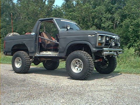 1986 Ford Bronco - This modified Ford Bronco features a roll cage and large off-road tires, suggesting it's built for terrain.