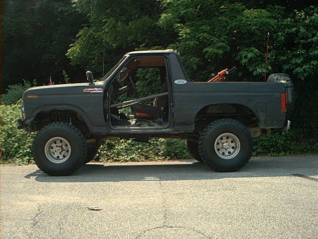Modified 1980s Ford Bronco with doors removed, roll cage, and off-road tires