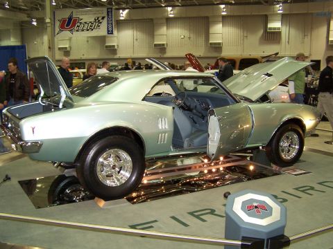 1995 Ford Probe - A classic 1967 Pontiac Firebird is displayed with its doors and hood open at a car show.
