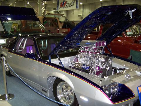 1995 Ford Probe - Customized silver and blue car with a prominent chrome engine and purple interior on display.