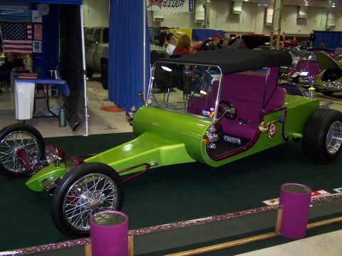 1995 Ford Probe - A custom-built hot rod with a distinctive green body and purple upholstery is displayed indoors.