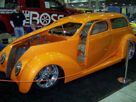 1995 Ford Probe - Custom hot rod sedan on display, with a red truck visible in the background.