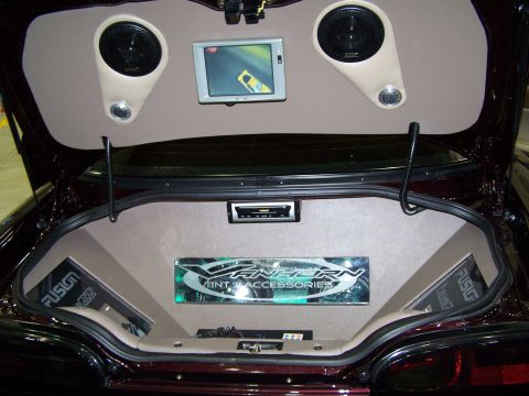 1995 Ford Probe - The interior of a car trunk is modified with a custom audio system, including speakers, a screen, and a stereo.