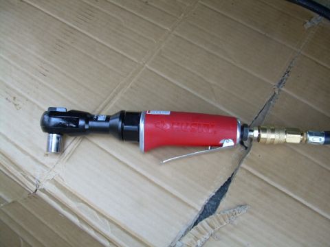 1988 Ford Bronco - A red Husky air ratchet is shown with a socket attached, resting on a surface of cardboard.