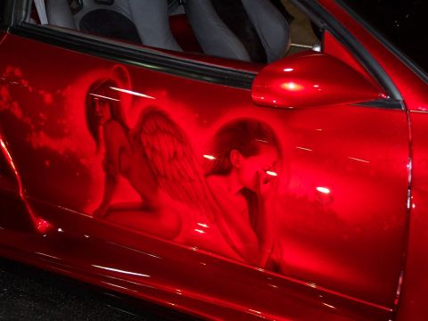 1995 Ford Probe - Custom airbrushed artwork of an angel adorns the side of a red vehicle.