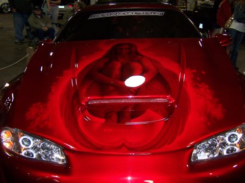 1995 Ford Probe - A custom airbrushed design of a woman in a bathtub adorns the hood of a red sports car.