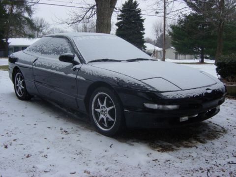 1995 Ford Probe - A black Ford Probe sits covered in snow on a winter day.