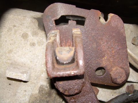 1988 Ford Bronco - Rusted transfer case linkage bracket, showing wear and corrosion.