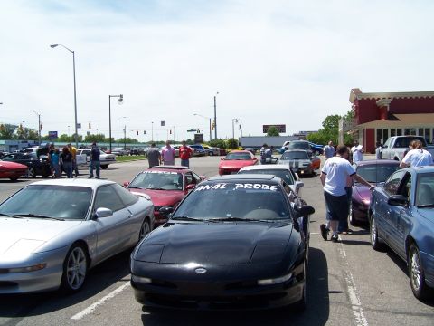 1995 Ford Probe - A group of Ford Probe cars are gathered in a parking lot on a sunny day.