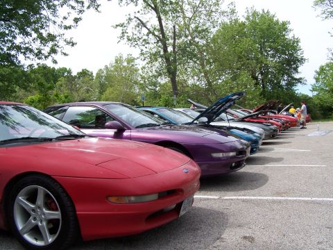 1995 Ford Probe - A line of Ford Probes are parked in a lot, with several having their hoods open.