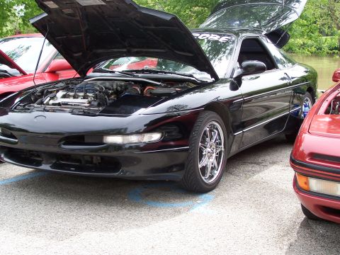 1995 Ford Probe - A black 1995 Ford Probe is shown with its hood and trunk open, parked alongside another vehicle.