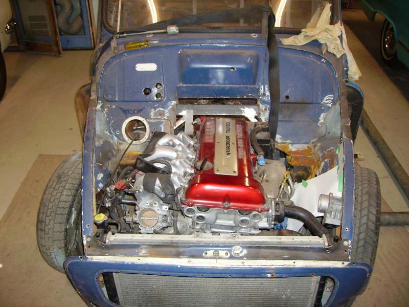 Blue Mini engine bay with red intercooled turbo engine swap in a garage