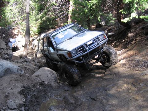 1994 Ford Bronco - This heavily modified SUV tackles a challenging off-road course, demonstrating its capability on rough terrain.