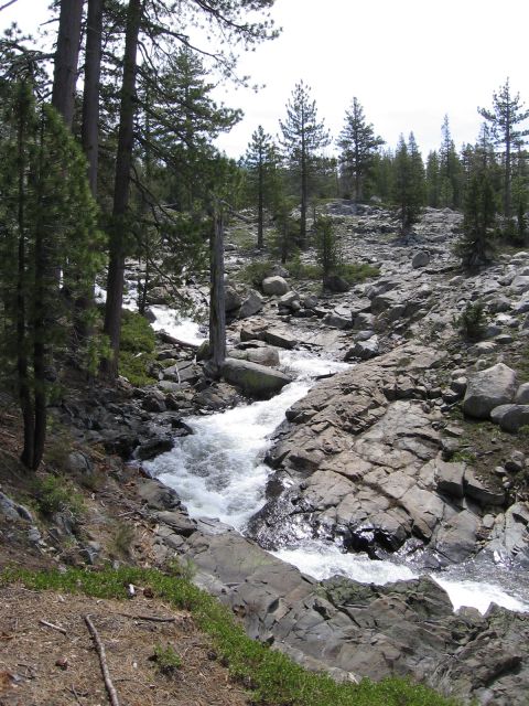 1994 Ford Bronco - A fast-flowing stream cascades over rocks in a wooded, mountainous area.