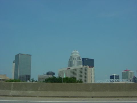 1995 Ford Probe - View of a city skyline from a highway, multiple buildings and a clear blue sky.