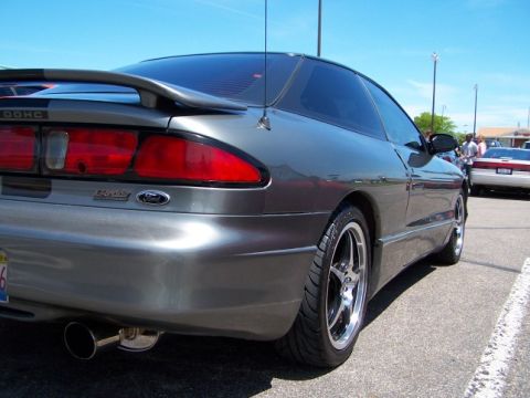 1995 Ford Probe - Rear view of a gray 1995 Ford Probe, a spoiler and custom wheels. Another car is visible in the background.