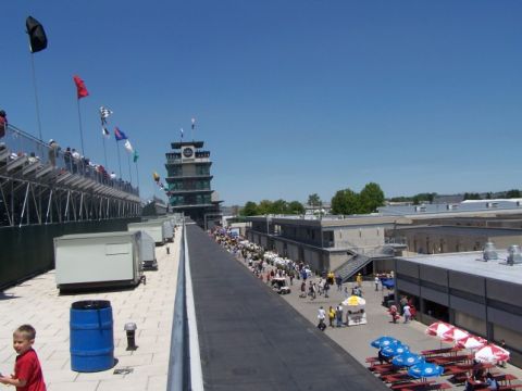 1995 Ford Probe - A wide view of the Indianapolis Motor Speedway shows the iconic tower and grandstands under a clear blue sky.