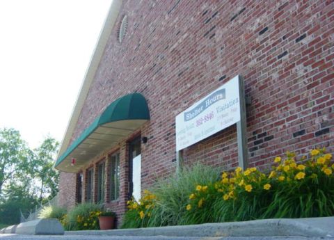 1995 Ford Probe - Exterior of a brick building with a green awning and a sign listing shelter hours and visitation.