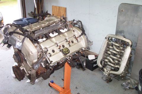 1995 Ford Taurus - Two engine assemblies are shown, one on an engine stand, in what appears to be a garage or workshop.