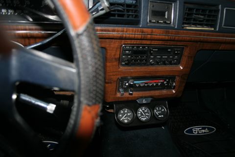 1989 Ford Crown Victoria LTD - The interior of a 1989 Ford Crown Victoria LTD shows wood grain accents, a stereo, and three auxiliary gauges.