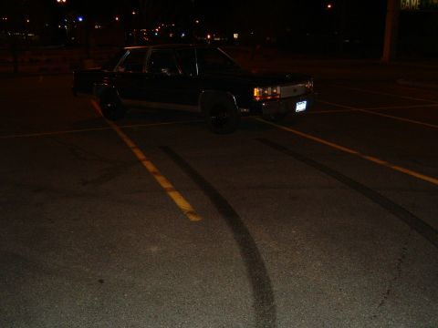 1989 Ford Crown Victoria LTD - Black Ford Crown Victoria parked in a lot at night, showing tire marks on the pavement.