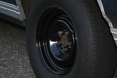 1989 Ford Crown Victoria LTD - Close-up of a car's wheel and tire, showing a black steel rim and chrome body trim.