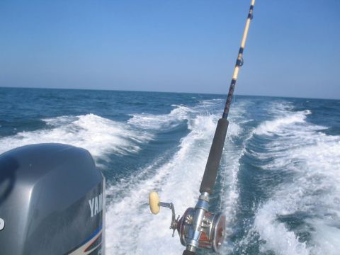 1979 Ford F-250 - A fishing rod and Yamaha outboard motor are visible as a boat speeds through the ocean, leaving a foamy wake.