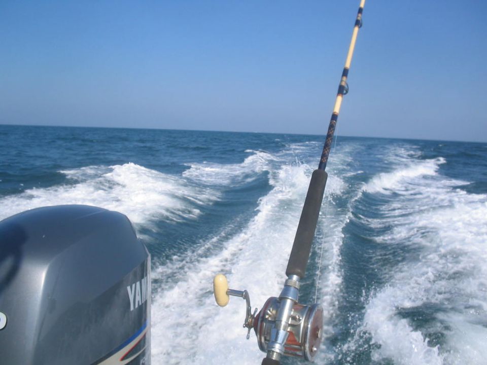 Yamaha outboard motor and fishing rod on a boat moving through water