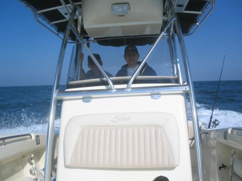 1979 Ford F-250 - Two people are on a boat, with the ocean in the background. The boat appears to be a Scout model.