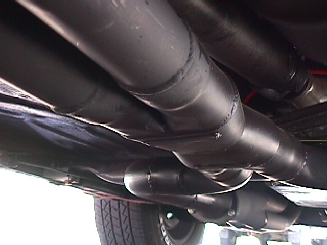 Underside view of dual exhaust pipes with visible welds