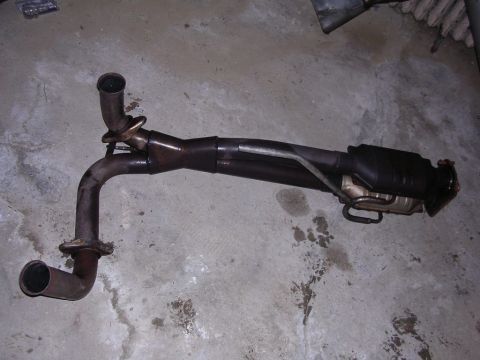 1991 Ford Bronco - Exhaust pipe assembly with catalytic converter is shown on a concrete floor.