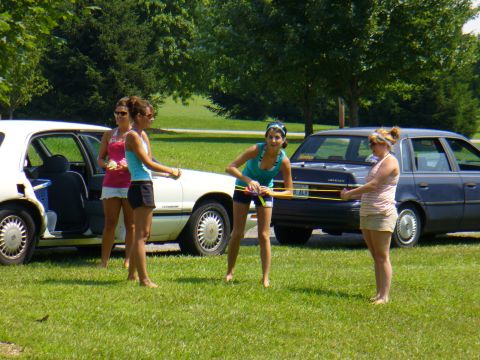 1991 Ford Probe - Two cars are parked on a grassy area with four women standing around them.