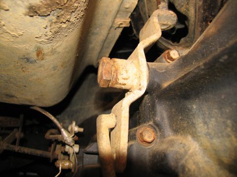 1978 Ford Bronco - This photo shows a close-up view of a rusty linkage mechanism attached to a vehicle's transmission housing.