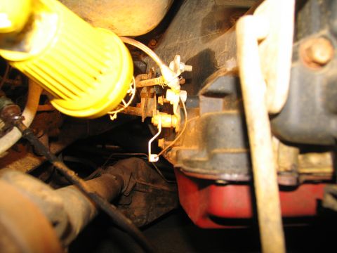 1978 Ford Bronco - Detail of engine or transmission components, including a yellow filter and metal linkage.