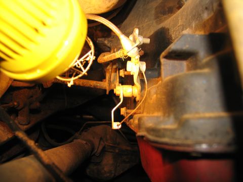 1978 Ford Bronco - Detail of a vehicle's transmission linkage, illuminated by a work light.