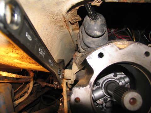 1978 Ford Bronco - Close-up of a wrench working on vehicle transmission linkage, part of a repair process.