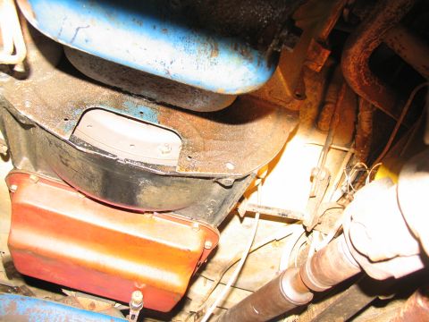 1978 Ford Bronco - Close-up view of the underside of a vehicle, focusing on the transmission and driveshaft components.