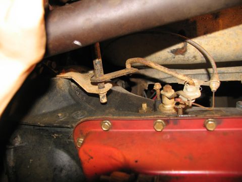 1978 Ford Bronco - Close-up view of vehicle undercarriage components, including rusty metal and a red transmission pan.