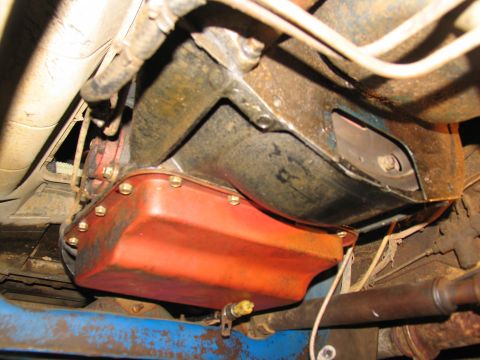 1978 Ford Bronco - Close-up view of the underside of a vehicle, focusing on the transmission and its oil pan.