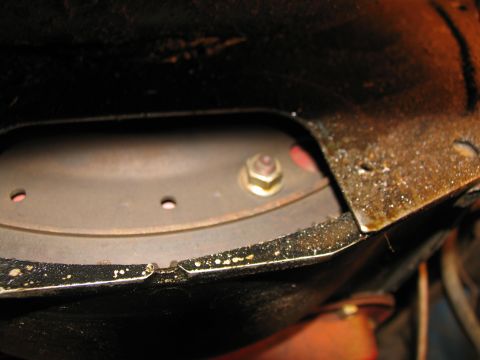1978 Ford Bronco - A close-up view of a bolt on the undercarriage of a vehicle, likely during transmission removal.