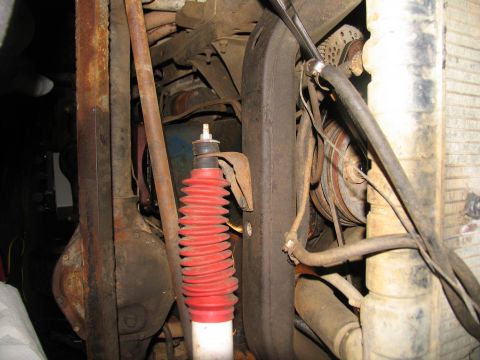 1978 Ford Bronco - Underside view of engine components including a shock absorber, hoses, and belts, with a radiator visible on the right.