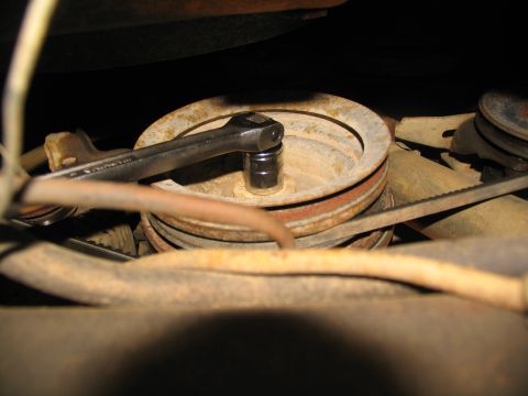 1978 Ford Bronco - A wrench is used to turn a pulley in a vehicle's engine compartment.
