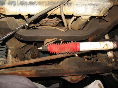 1978 Ford Bronco - Close-up view of the undercarriage, focusing on a shock absorber and various suspension components.