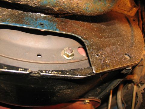 1978 Ford Bronco - Underside view of vehicle parts, rusty metal and oil residue.
