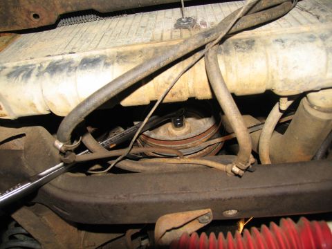1978 Ford Bronco - A wrench is used to turn an engine pulley and belt, likely during transmission removal or maintenance.