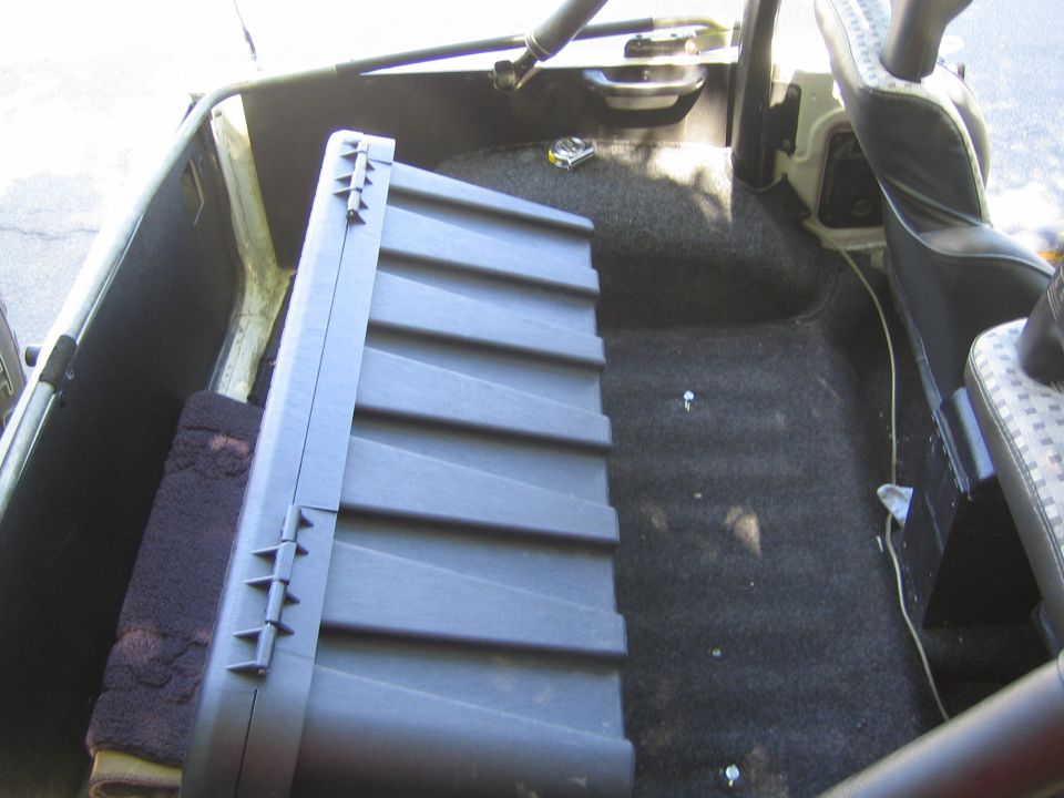 Interior cargo area with a large black storage box and carpeted floor