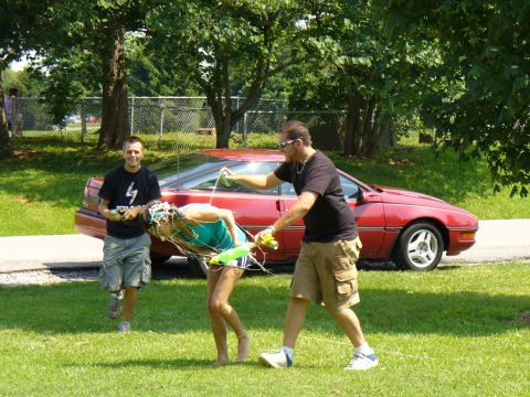 1991 Ford Probe - A red coupe with a unique body style is visible in the background of a playful outdoor scene.