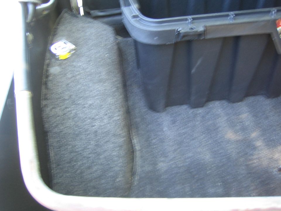 Interior trunk storage compartment with a circular emblem