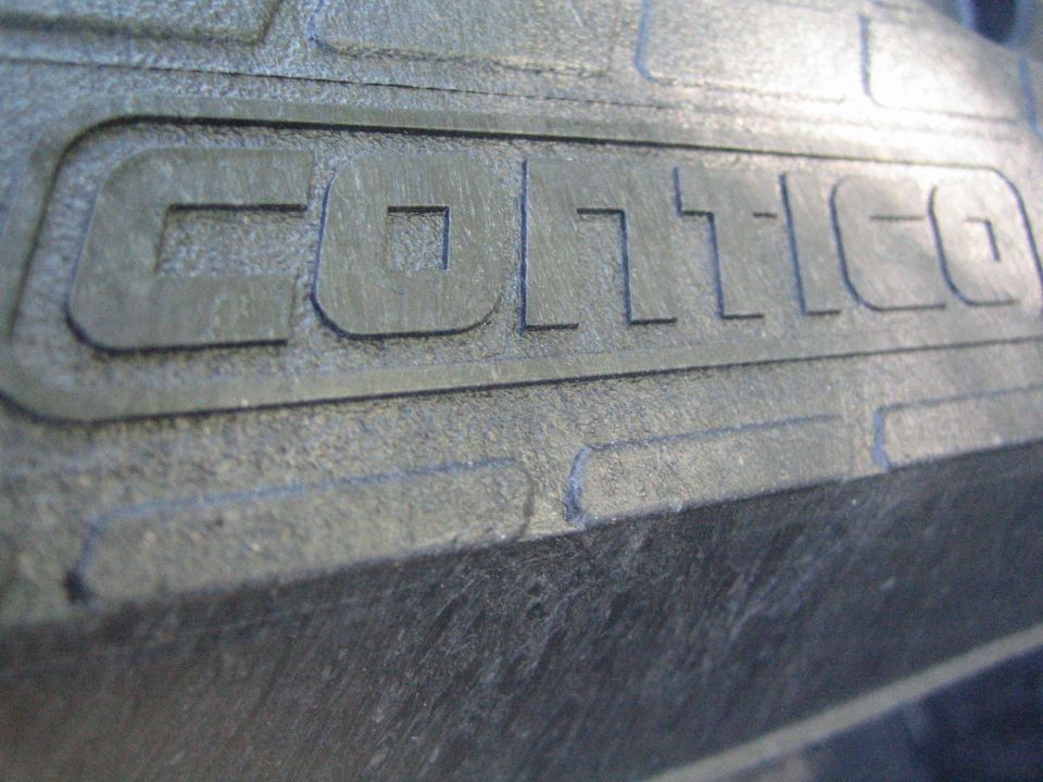 Black textured part with raised "COLT" lettering